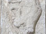 relief représentant le visage d'un homme sur un bloc de pierre