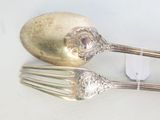 deux cuillères et une fourchette en argent sur une table