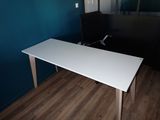 a white table with a black chair next to it