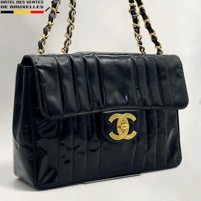 a black chanel bag with gold hardware and chain handles