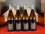 three bottles of wine sit on a table next to wooden crates
