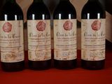 three bottles of red wine are lined up on a red table