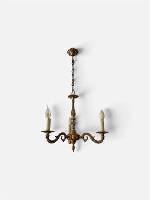 un lustre ancien en laiton avec trois bougies suspendues au plafond