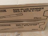 two boxes of drill bits sitting on top of a table