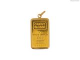 un pendentif en forme de lingot d'or sur lequel est inscrit « carte de crédit »
