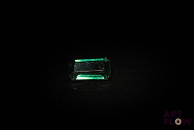 un gros plan d'une émeraude verte sur une surface noire