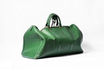 un sac à main vert posé sur une surface blanche