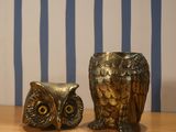 an owl statue next to a plate on a table