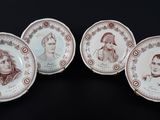 quatre assiettes ornées de portraits sur fond noir
