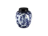un vase bleu et blanc posé sur une surface blanche