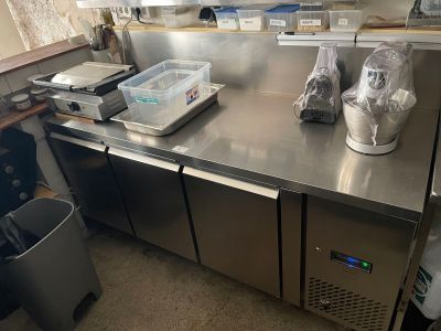 a stainless steel counter in a kitchen with a trash can