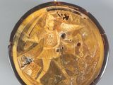 a gold plate with a picture of a man riding a horse