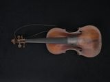 an old violin on a black background with a string