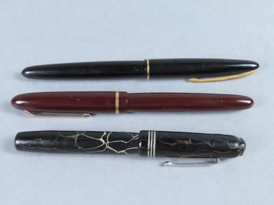trois types de stylos différents sont alignés sur une surface blanche
