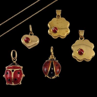 four gold and enamel ladybug pendants and a gold chain