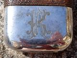 a silver flask with a monogram on it