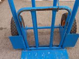 a blue hand truck with a blue handle on the ground