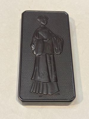 un étui noir sur lequel figure l'image d'une femme en robe