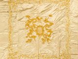 une nappe ancienne brodée, jaune et blanche, ornée d'un motif floral
