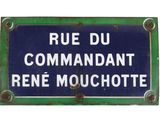 blue and white street sign on a green metal plate with rusted edges