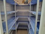 a long shelf in the middle of a room with blue shelves
