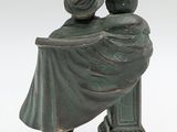 figurine of a man and woman sitting on a bench