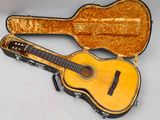 une image représentant une guitare dans son étui, posée sur une surface blanche