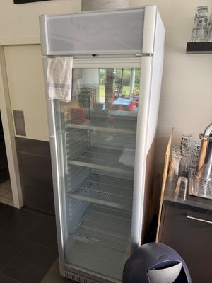 un réfrigérateur avec une porte en verre dans une cuisine