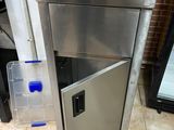 a stainless steel sink with a door open on a tiled floor