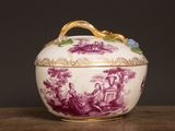 purple and white porcelain bowl with a gold handle on a wooden table