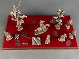 silver figurines of a group of people on a red surface