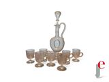 a silver and glass decanter and cups on a table