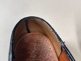 someone is cleaning a pair of brown shoes on a white surface