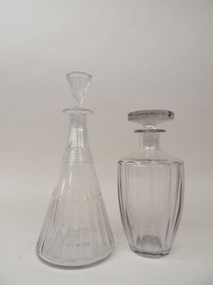 two glass bottles sitting next to each other on a white surface