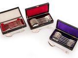 three silver plated spoons and forks in a black case