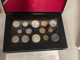 a box of coins sitting on a table next to a sheet of paper