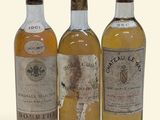trois bouteilles de vin posées les unes à côté des autres sur une surface blanche