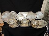 de nombreux plats et plateaux en argent posés sur une table