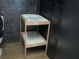 a small bathroom with a black toilet and a wooden table