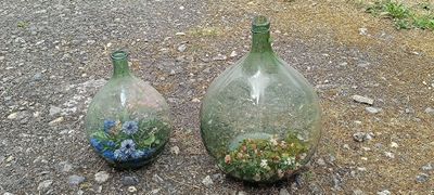 two vases sitting on the ground next to each other