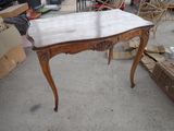 a table with a marble top in the middle of a yard
