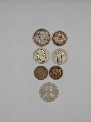 several different coins are arranged in a row on a white surface