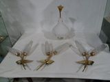 quatre vases en verre et un vase doré posés sur une table blanche