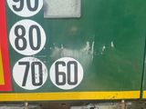 a green and yellow train with numbers on the side