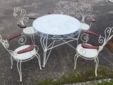 une table blanche et quatre chaises dans un parking