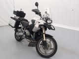 une moto garée dans une pièce aux murs blancs