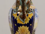 a blue and yellow vase with a bird on it