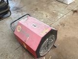 une machine rose posée par terre dans un garage