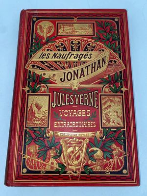 an old book with a red cover and gold lettering on it