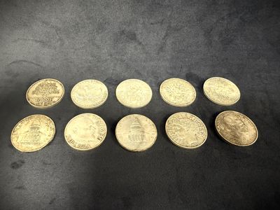a bunch of gold coins sitting on top of a black surface
